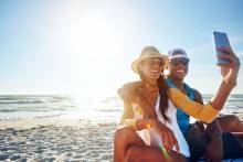 A couple take a selfie during sunset on the beach